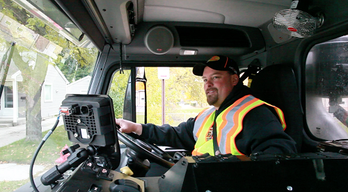 A DPW garbageman drives on his route.